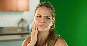 Woman holding jaw in pain