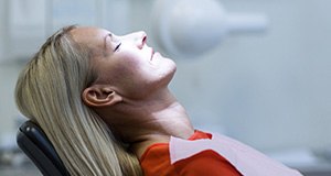 Relaxing woman with eyes closed in dental chair