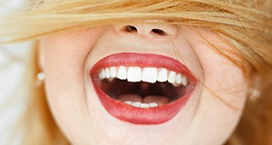 Close-up of a white smile with red hair covering face